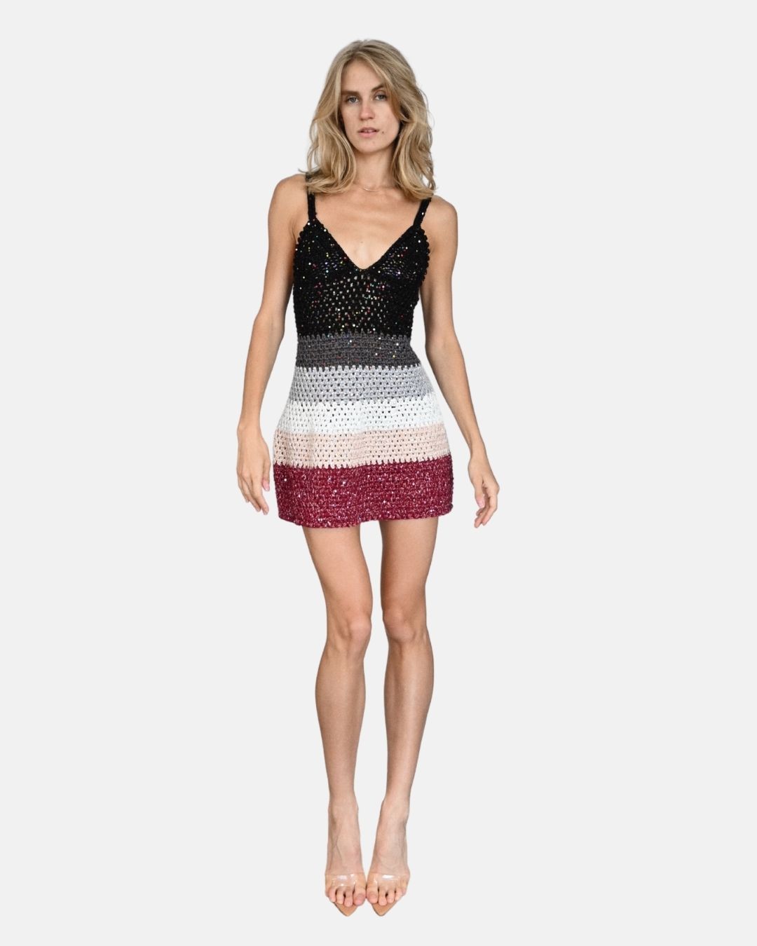 Full-length front view of a model wearing the Sienna mini dress, showing the multi-color gradient crochet stripes and V-neckline.