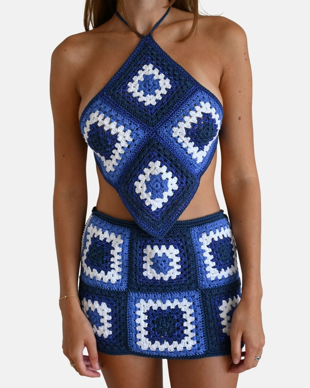 Front view of a model wearing the matching Bianca crochet top and mini skirt, showcasing the complete blue artisanal set.