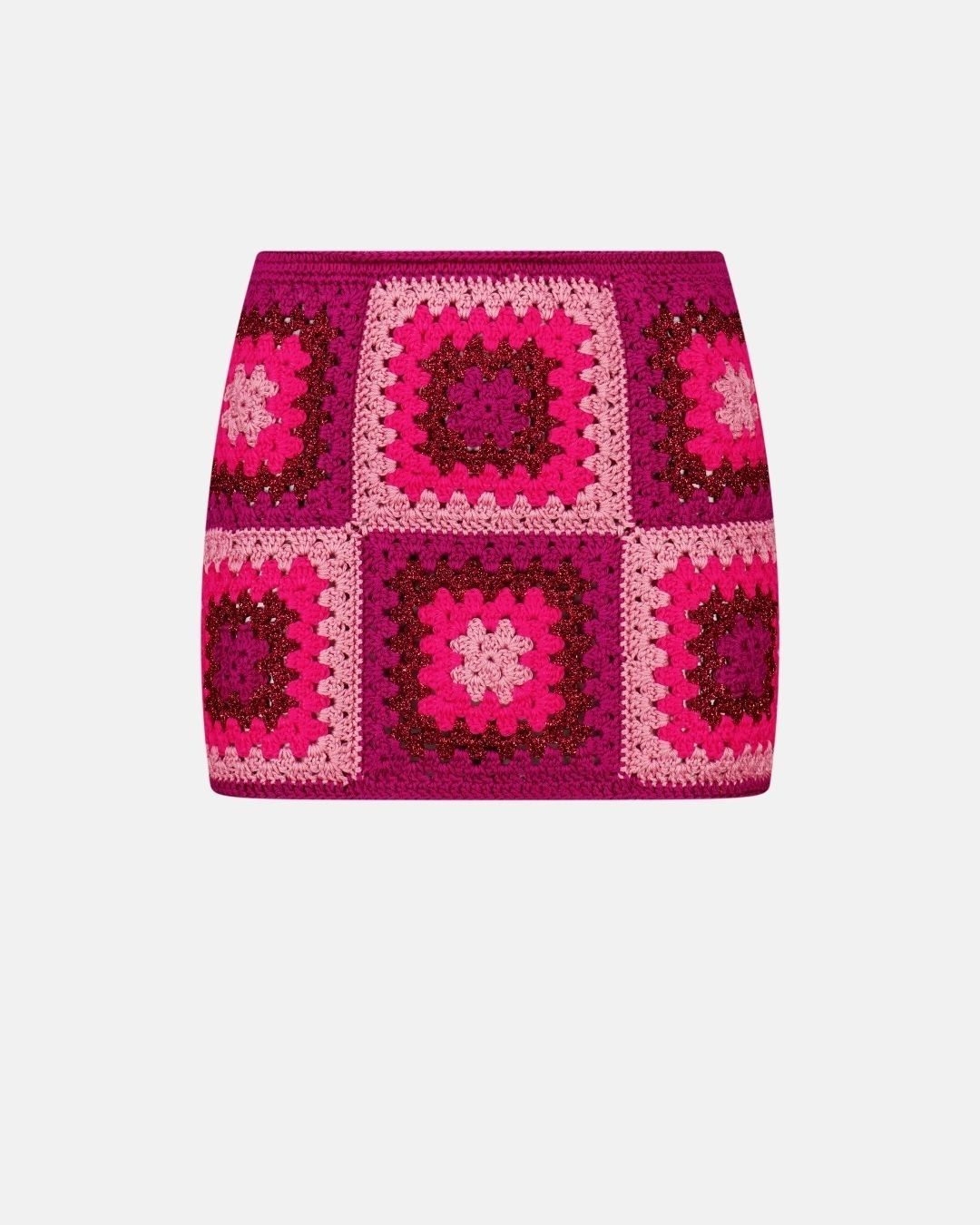 A studio front view of the Bianca crochet mini skirt in cherry and fuchsia tones, highlighting the geometric patchwork and artisanal knit.