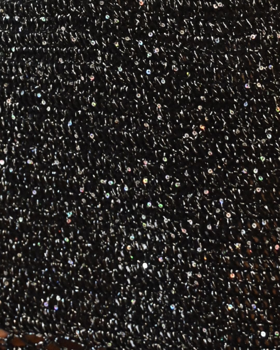 Extreme close-up of the Melissa dress fabric, showing the artisanal hand-crocheted black knit infused with thousands of shimmering silver micro-sequins.