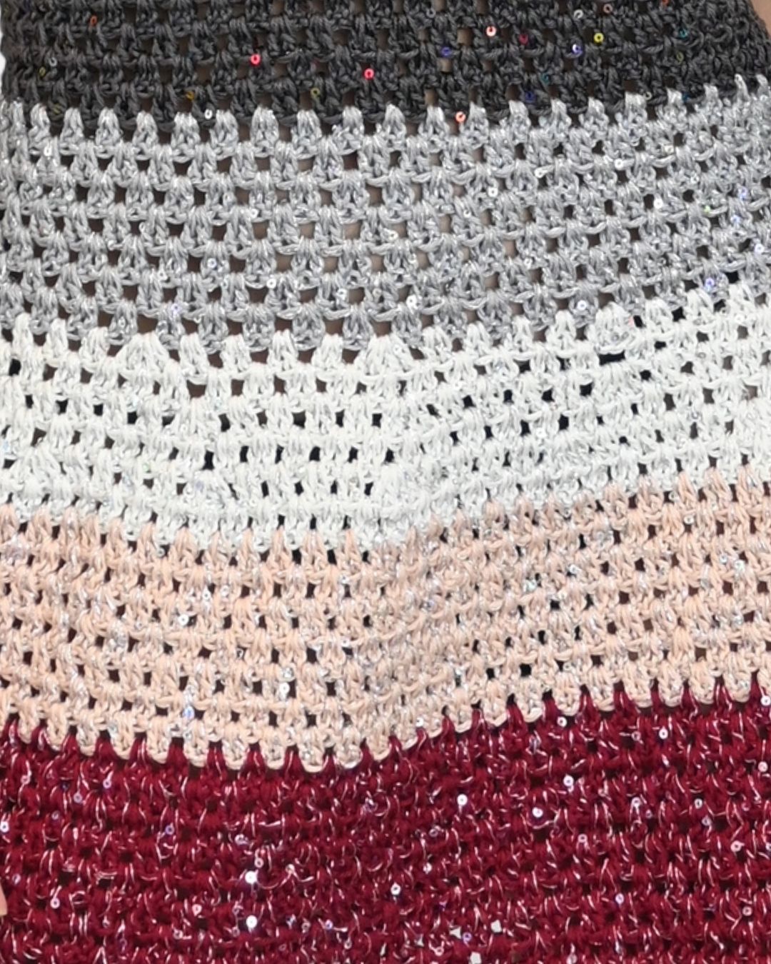 Extreme close-up of the Sienna dress fabric, showing the intricate hand-crocheted stripes in grey, white, and peach with embedded sequins.